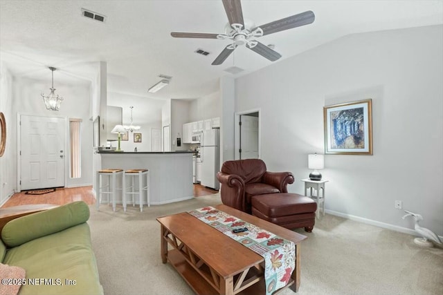 living area with visible vents, light carpet, vaulted ceiling, baseboards, and ceiling fan with notable chandelier