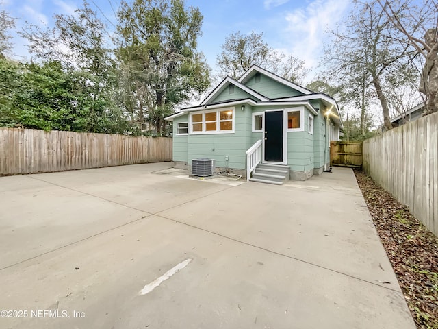 rear view of house featuring entry steps, central AC, a patio area, and a fenced backyard