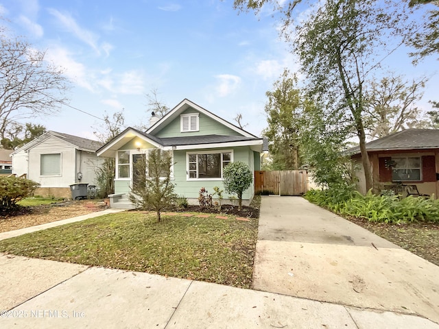 bungalow featuring fence and a front lawn