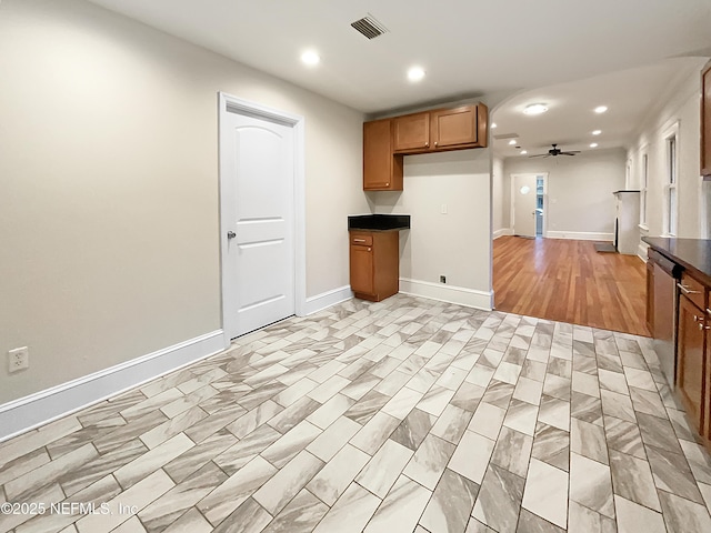 kitchen with ceiling fan, visible vents, dishwasher, brown cabinetry, and dark countertops