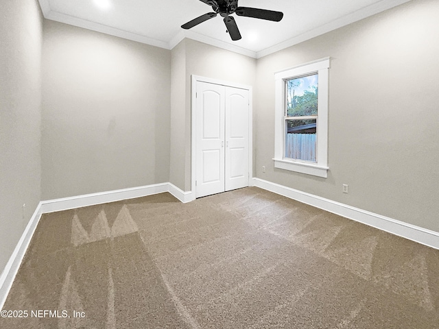 unfurnished bedroom with crown molding, carpet, and baseboards