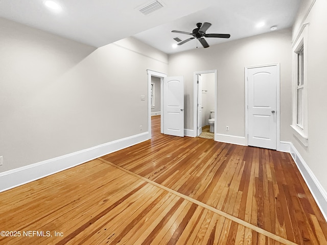 unfurnished bedroom with baseboards, visible vents, wood finished floors, ensuite bathroom, and recessed lighting