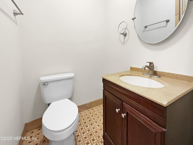 bathroom featuring vanity, toilet, and baseboards