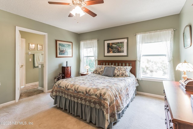 bedroom featuring ceiling fan, a textured ceiling, connected bathroom, light carpet, and baseboards