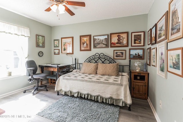 bedroom with light wood-style flooring, baseboards, and ceiling fan