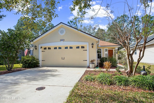 view of front of home with driveway, an attached garage, and stucco siding