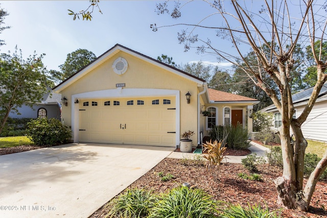 view of front of property featuring a garage, driveway, and stucco siding