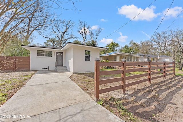 view of front facade with a fenced front yard and stucco siding