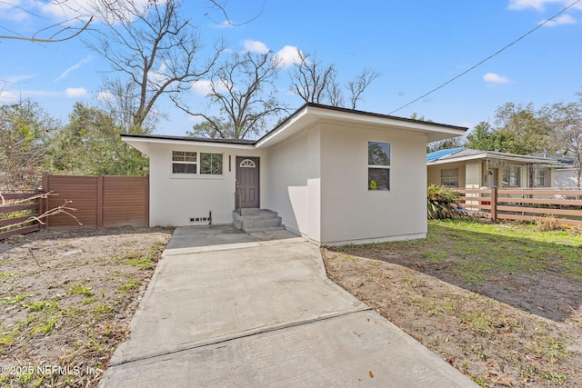 view of front of property with fence and stucco siding