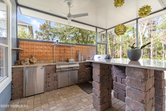 view of patio / terrace featuring ceiling fan and exterior kitchen