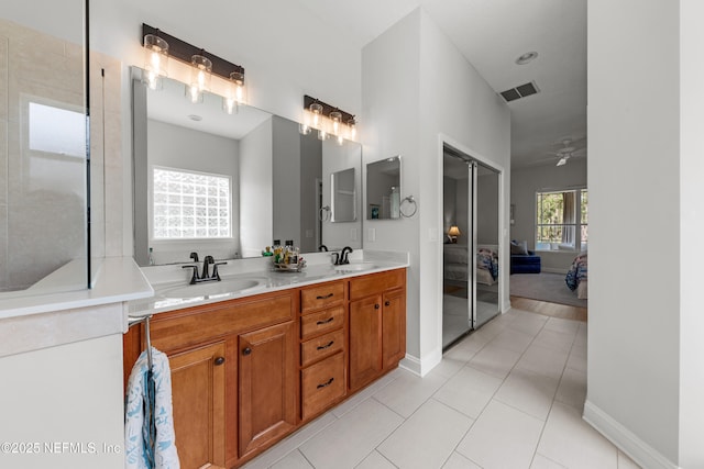 bathroom featuring ensuite bathroom, tile patterned flooring, a sink, visible vents, and double vanity