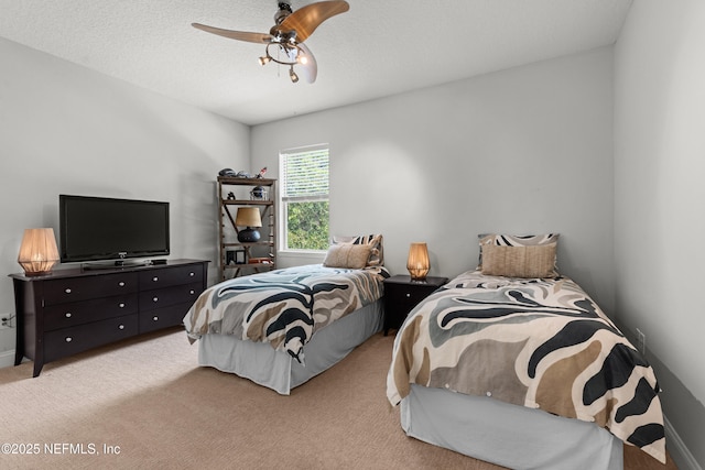 bedroom featuring a textured ceiling, a ceiling fan, and light colored carpet