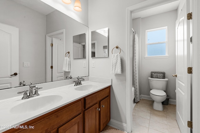 full bath with double vanity, baseboards, toilet, tile patterned flooring, and a sink