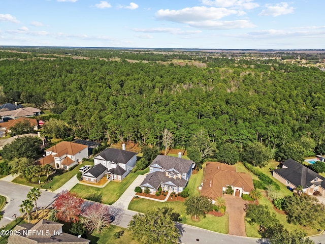 drone / aerial view featuring a residential view and a forest view