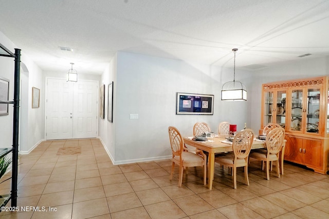 dining space featuring light tile patterned floors, baseboards, and visible vents