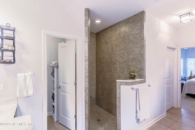 full bath featuring a textured ceiling, a walk in shower, connected bathroom, and tile patterned floors