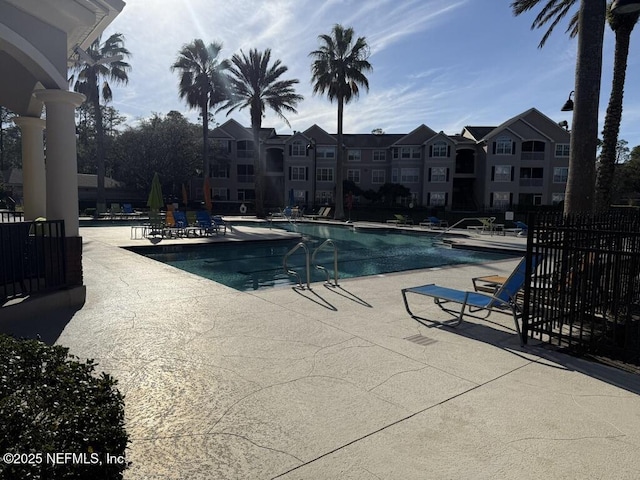 community pool featuring a patio area and fence