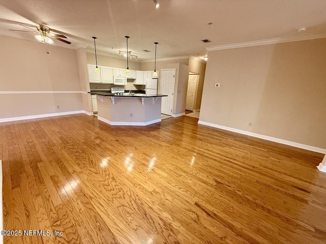 unfurnished living room featuring light wood-style flooring, baseboards, ceiling fan, and crown molding