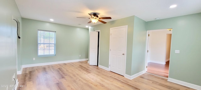 unfurnished bedroom with a ceiling fan, baseboards, light wood finished floors, recessed lighting, and multiple closets