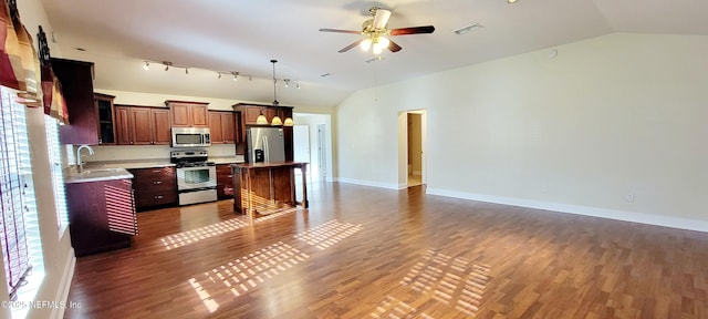 kitchen with visible vents, a sink, open floor plan, appliances with stainless steel finishes, and vaulted ceiling