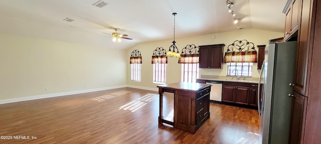 kitchen featuring a center island, dark wood-style floors, stainless steel appliances, and lofted ceiling