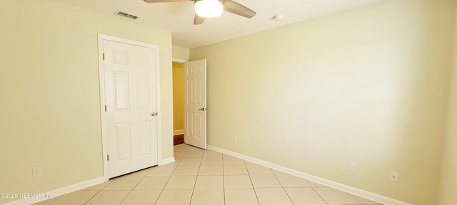 unfurnished room featuring light tile patterned floors, visible vents, a ceiling fan, and baseboards