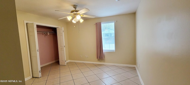 unfurnished bedroom featuring light tile patterned floors, baseboards, a closet, and ceiling fan