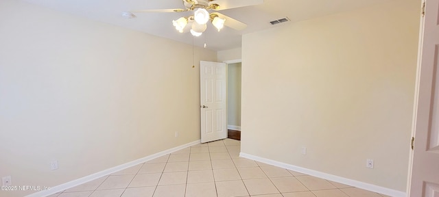 spare room featuring light tile patterned floors, visible vents, baseboards, and a ceiling fan