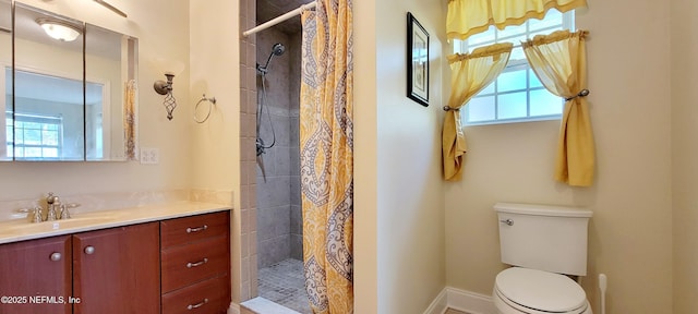 bathroom with vanity, toilet, baseboards, and a stall shower