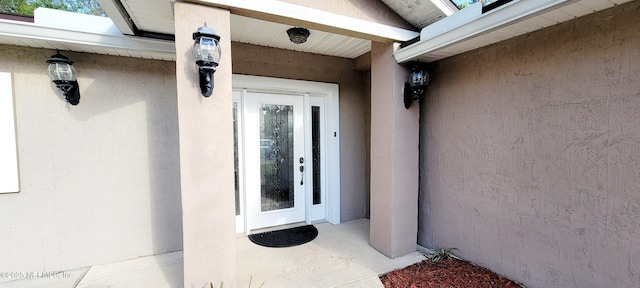 doorway to property featuring stucco siding