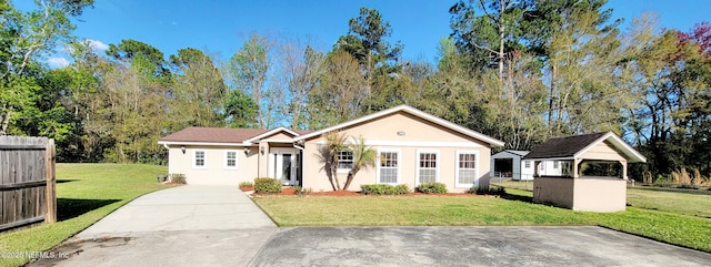 view of front of house with a front yard, driveway, and stucco siding