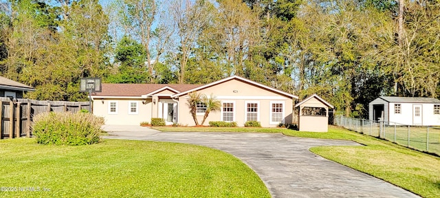 view of front of property with a front lawn, driveway, and fence