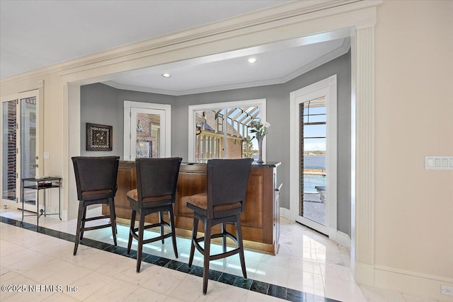 bar featuring a bar, recessed lighting, baseboards, and ornamental molding