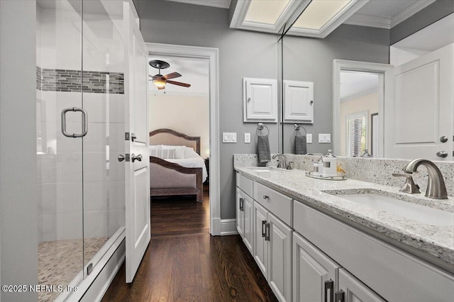 full bathroom with ornamental molding, a sink, a shower stall, ensuite bath, and wood finished floors