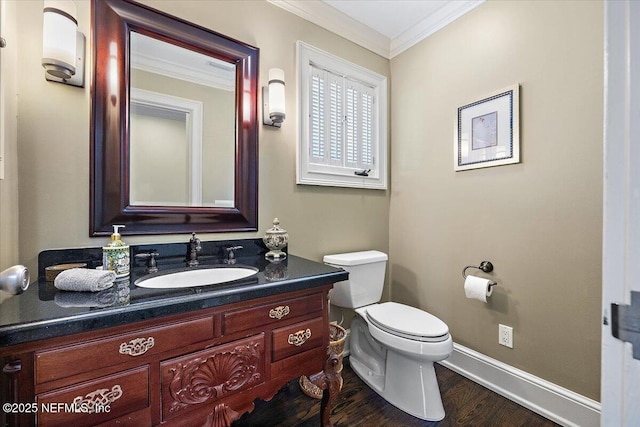 half bathroom with baseboards, toilet, wood finished floors, crown molding, and vanity