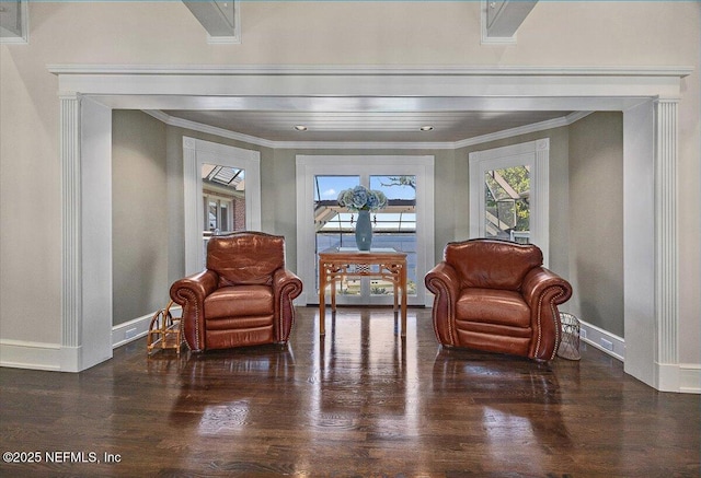 sitting room featuring dark wood-style floors, baseboards, and crown molding