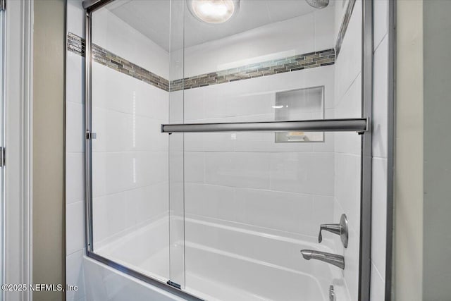 bathroom with combined bath / shower with glass door