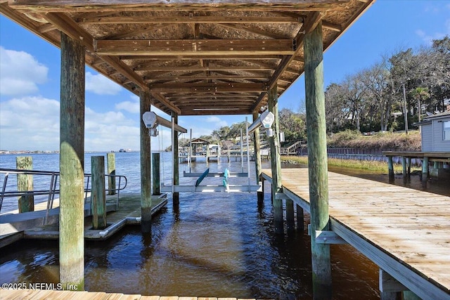 dock area with a water view and boat lift