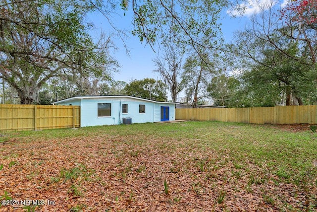 view of yard with central AC unit and a fenced backyard