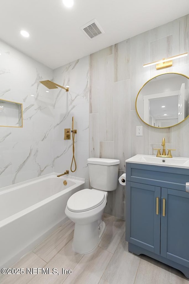 full bath with toilet, vanity, visible vents, tile walls, and  shower combination