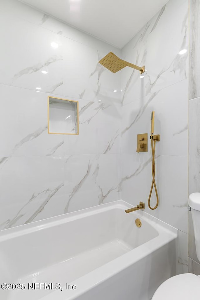 bathroom featuring toilet and washtub / shower combination