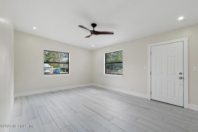 unfurnished room with light wood finished floors, recessed lighting, a ceiling fan, and baseboards