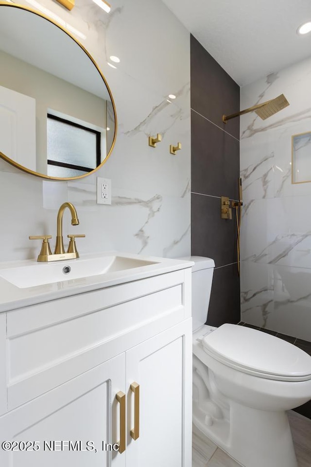 full bath with toilet, vanity, tile walls, marble finish floor, and a marble finish shower