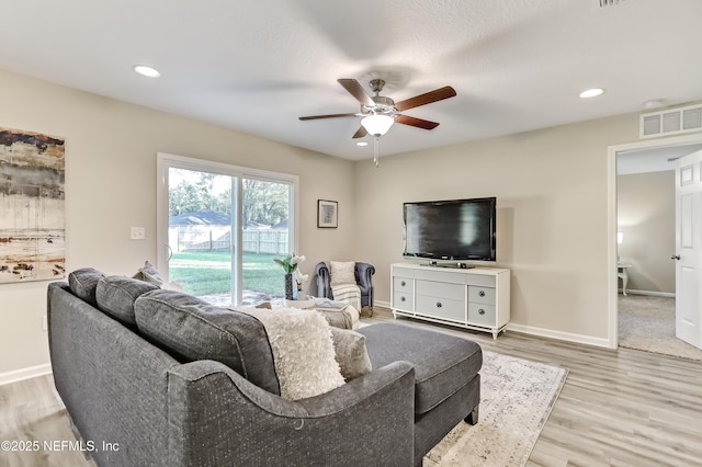 living area featuring a ceiling fan, light wood-type flooring, baseboards, and recessed lighting