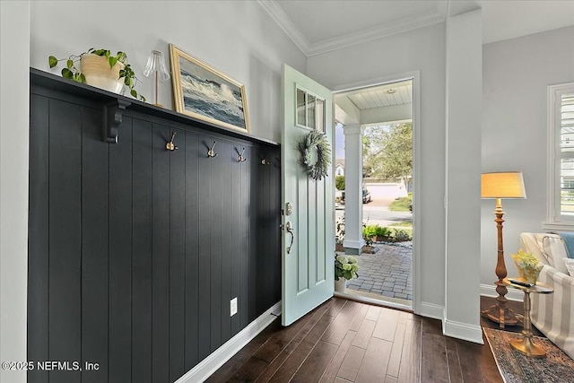 interior space with ornamental molding, dark wood finished floors, and baseboards