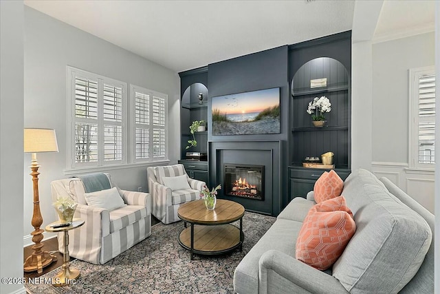 sitting room with built in features and a glass covered fireplace