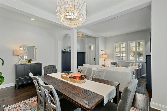 dining area with crown molding, dark wood finished floors, recessed lighting, an inviting chandelier, and baseboards