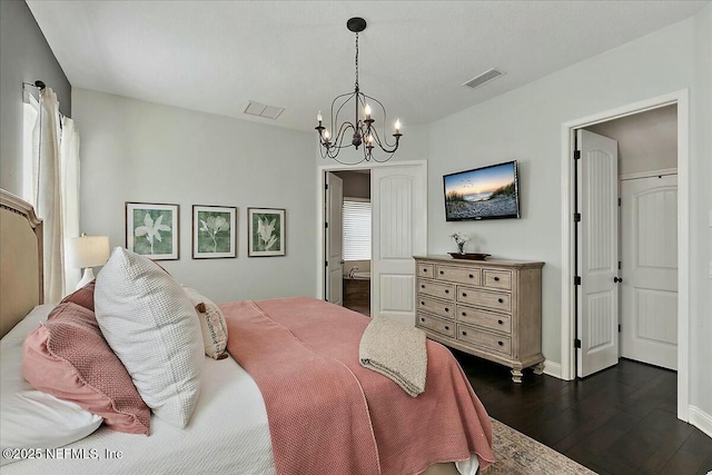 bedroom with a chandelier, dark wood-style flooring, visible vents, and baseboards