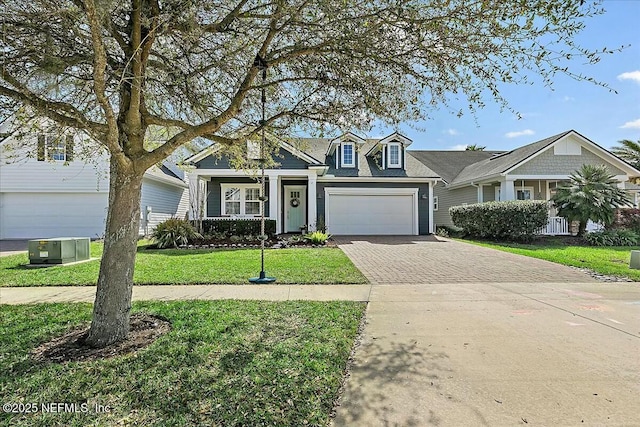 view of front of property with an attached garage, a front lawn, and decorative driveway