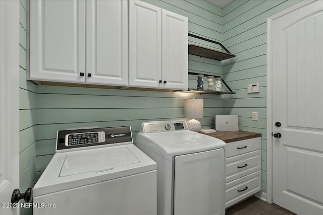 clothes washing area featuring cabinet space and separate washer and dryer